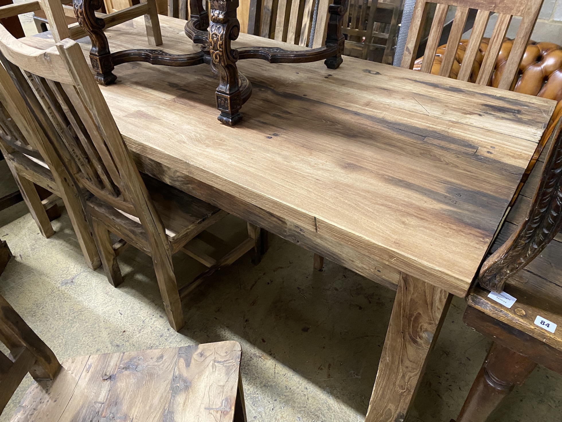 A rectangular hardwood dining table, length 200cm, depth 90cm, height 80cm and eight chairs, teak from reclaimed boat timbers